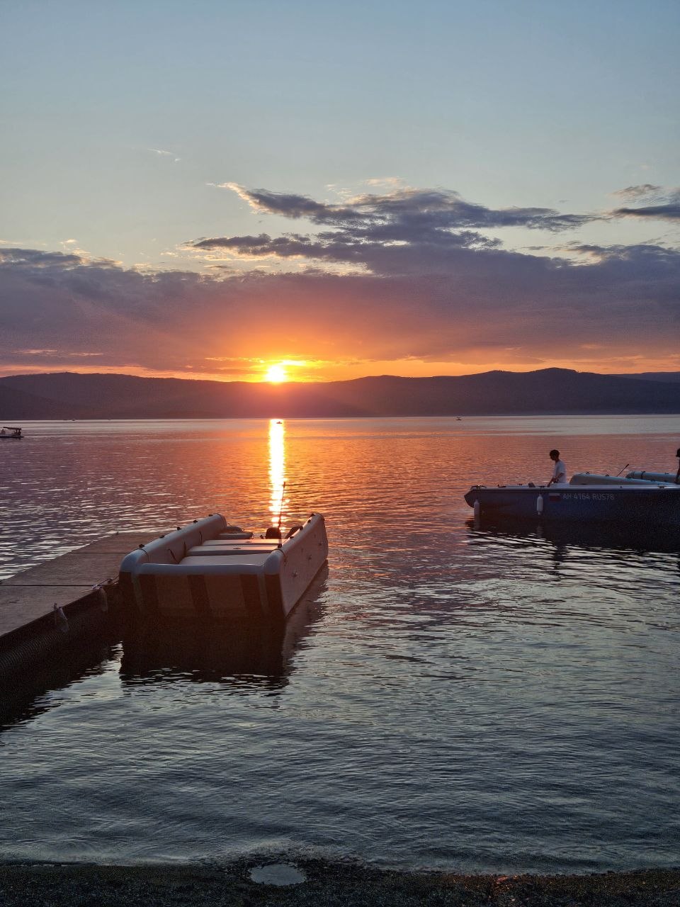Тургойак на закате и электролодки у пирса.